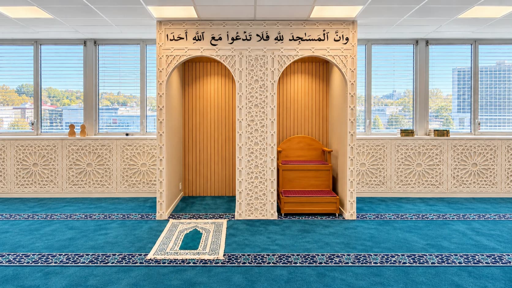 Mihraben og minbaren i Masjid Rahma, under verset fra Koranen 72:18, med bønneteppet foran.